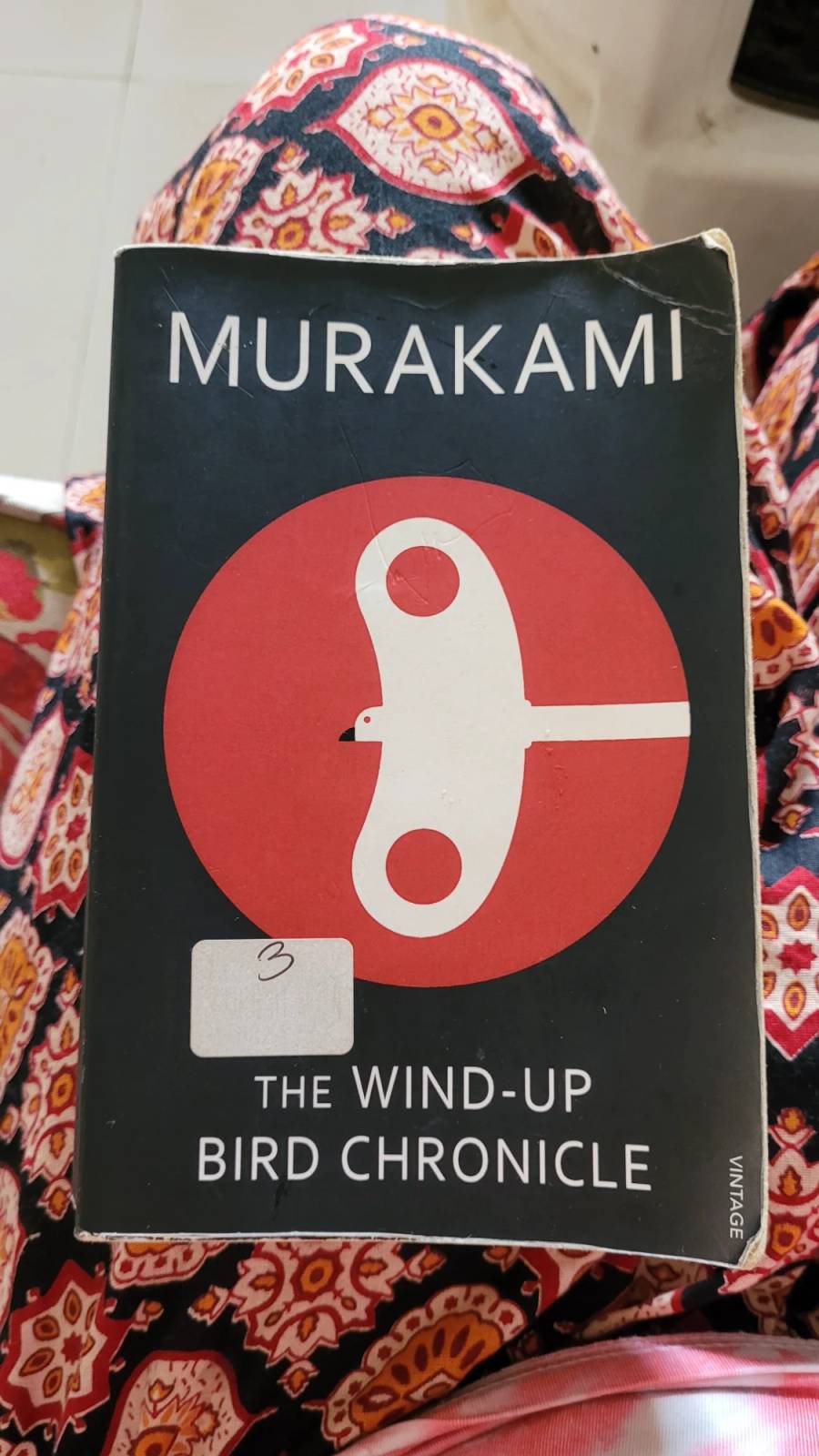 The Wind-Up Bird Chronicle book with a black cover, red circle, white wind-up bird design, and library sticker.