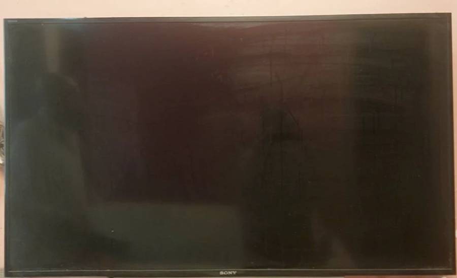 Black Sony LED TV with a black frame, showing visible smudges and marks on the screen.