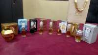 A collection of Smart Collection perfume miniatures in various bottles and boxes, mostly new, displayed on a red surface.